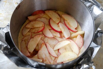 <p>Форму удобнее использовать разъемную. Смажьте ее маслом и вылейте половину теста. Затем выложите яблоки (2/3 части) по всей поверхности, оставив немного для украшения. Если получится, можно сделать несколько слоев тесто-яблоки. </p> 