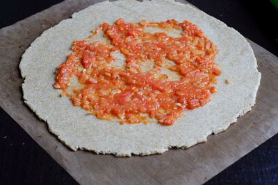 <p>Готовое тесто раскатайте в пласт толщиной около 5 мм. Оступив 5 см от краев намажьте серединку томатным соусом. </p> 